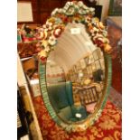 An oval barbola free-standing mirror with ornate floral decorated painted frame