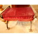 A 20th C scrolling wrought iron x-frame stool with red upholstered cushion seat