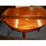A mahogany cross banded circular dining table with extending leaf