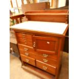 An Edwardian oak dentist's cabinet the opaline glass top over a series of instrument drawers and