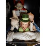 A ceramic playing card box surmounted with a devil, three piano babies,