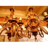 A pair of stylish turned wood and scrolled metal work five branch chandeliers