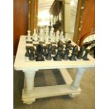 A cream painted pine square coffee table with chess board top and a carved chess set