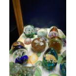 A collection of seventeen unsigned glass paperweights