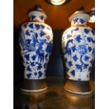 A pair of Chinese blue and white lidded vases decorated with Asiatic pheasants amongst flowers