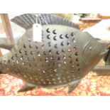 A large hanging iron candle holder in the form of a fish