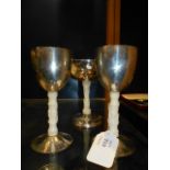 Three white metal and carved ivory goblets depicting animals in the wild
