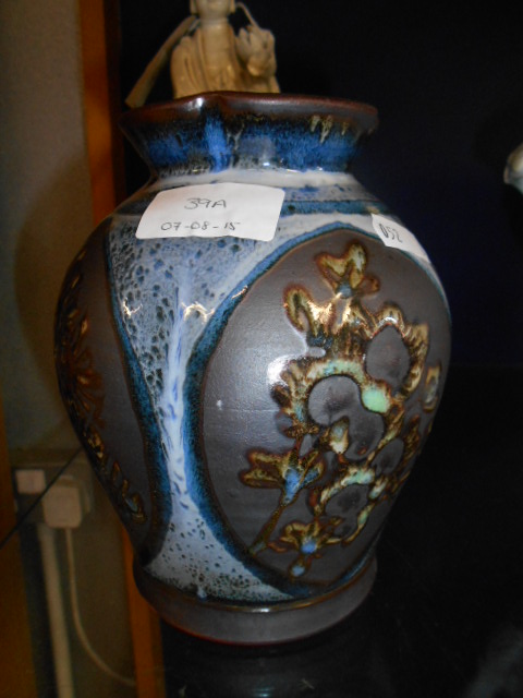 A David Eeles studio pottery slip-ware of lobbed form decorated with flower,