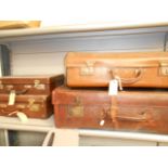 A vintage leather suitcase and three other's