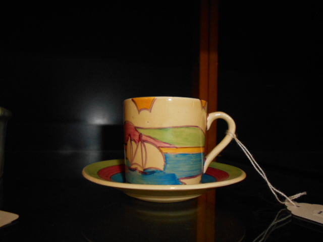 A Clarice Cliff Fantasque Bizarre coffee can and saucer having sailing boat scene  Saucer good