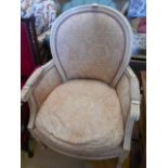 A 20th C cream painted bedroom chair the spoon back over scrolling arms and over stuffed seats