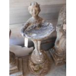 A reconstituted stone bird bath in the form of a young girl