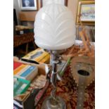 An art deco chrome table lamp of column form with moulded milk glass shade