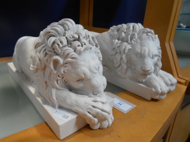 A pair of high quality crushed marble recumbent lions with medallions inset to base