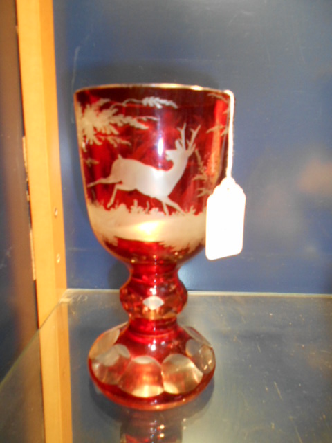 A 19th C Bohemian ruby glass goblet wheel engraved with deer in amongst trees,