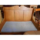 A 20th C pine high back pew with shaped panelled back scrolling arms and serpentine apron and