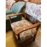 A mid 20th C oak framed open armchair with floral tapestry and studded back and seat,