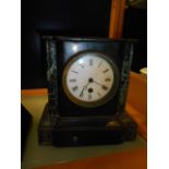 A Victorian slate and marble mantel clock with white enamel dial and Roman numerals,