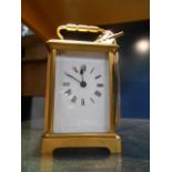 A 20th C brass carriage clock with bevel glass viewing panels,