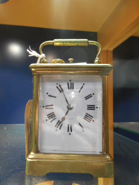 A 20th C repeating brass carriage clock with bevel glass viewing panels,
