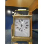 A 20th C repeating brass carriage clock with bevel glass viewing panels,