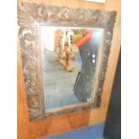 A late 19th C oak Black Forest style wall mirror the frame heavily carved with scrolling leaves