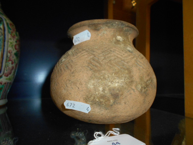 A circa 1000 BC terracotta jar of ovoid form incised with geometric designs,