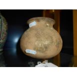 A circa 1000 BC terracotta jar of ovoid form incised with geometric designs,