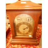An early 20th C oak cased Kienzle chiming bracket clock the floral engraved silvered dial with