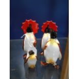 A group of four Beswick 'Penguins' two with red umbrellas A/F