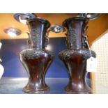 A pair of Chinese bronze two handled vases with applied floral decoration 22 cm tall