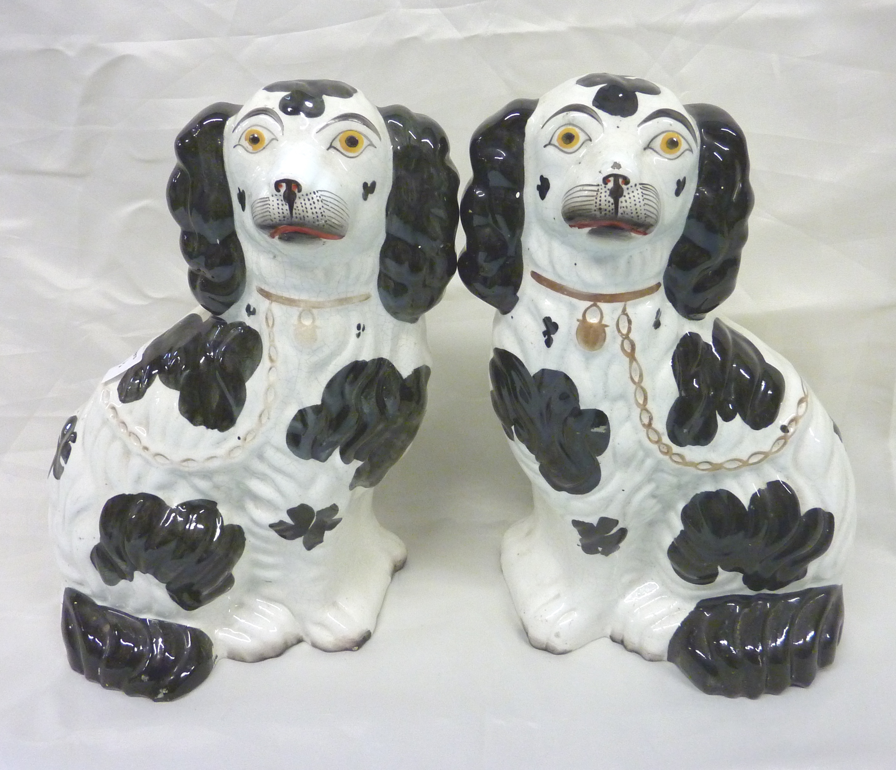 Pair of Staffordshire black and white seated spaniels