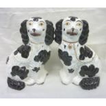 Pair of Staffordshire black and white seated spaniels