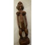 Mid 19thC Nigerian wood carved figure in a squatting position,