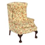 Property of a lady - an early C20th George III style wing armchair with pale yellow ground floral