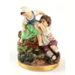 Property of a deceased estate - a C19th porcelain group of a boy and a girl picking berries on