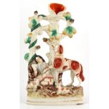 A Victorian Staffordshire spill vase modelled as a shepherd resting with sheep & hound, 11.5ins. (