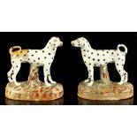 A pair of Staffordshire models of standing dalmatians, circa 1900, restoration to one, each