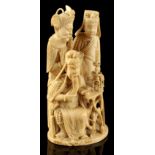 A late C19th Chinese carved one-piece ivory group of three Immortals, one modelled seated at a table