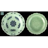 An 18th century Chinese celadon glazed shallow dish with barbed rim, with underglaze blue moulded