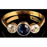 An 18ct yellow gold diamond & sapphire three stone ring, the central sapphire flanked by two