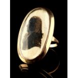 An unmarked Georgian gold ring, the glazed oval cream silk panel reverse painted with a silhouette