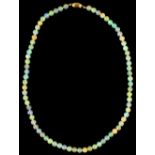 An opal bead necklace, the 74 uniform beads approximately 6mm diameter, with 18ct gold melon
