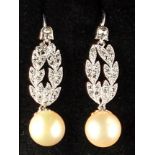 A pair of diamond & pearl drop earrings, each with millegrain set diamond laurel leaves above a