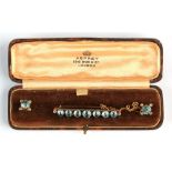 An early 20th century unmarked gold bar brooch set with seven pale blue stones, possibly aquamarines