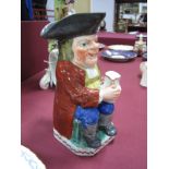 An Early XIX Century Pearlware Pottery Toby Jug, polychrome painted and modelled in traditional form