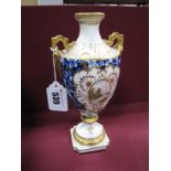 An Early XX Century Coalport China Two Handled Pedestal Urn Vase, painted and gilt, reserved with an