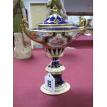 A Royal Crown Derby Bone China Pedestal Urn Vase and Cover, of oval section, reserved with panels of