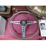 An Early 1960's Jaguar E-Type Steering Wheel, having wooden rim and central Jaguar motif.