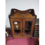 A 1920's Oak Smokers Wall Cabinet, with shaped gallery twin bevelled glass doors and inner